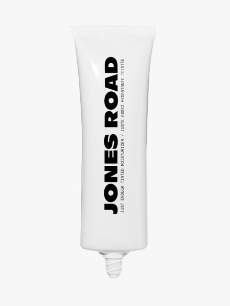 Jones Road Just Enough Tinted Moisturizer in branded tube component on a light gray background